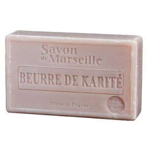 Un săpun etichetat „Săpun Natural de Marseille cu Ulei de Shea (Karité)” cu „Made in France” inscripționat în partea de jos în centru. Săpunul este bej și dreptunghiular cu margini netede.