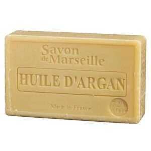 Un săpun dreptunghiular bej, în relief cu „Savon de Marseille”, sintagma „HUILE D'ARGAN” cu caractere mai mari și „Made in France” în partea de jos. Acest Săpun Natural de Marseille cu Ulei de Argan conține 72% ulei.