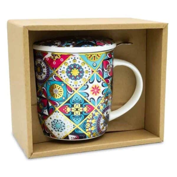 O Ceașcă din ceramică pentru Ceai cu Infuzor, Orientală, cu un model geometric și floral colorat, complicat este expusă într-o cutie de carton. Aceasta ceasa pentru ceai are maner si capac asortat, cu infuzor inclus pentru comoditate. O lingură de metal este plasată deasupra cănii. Designul prezintă albastru, roșu, galben și alb vibrant.