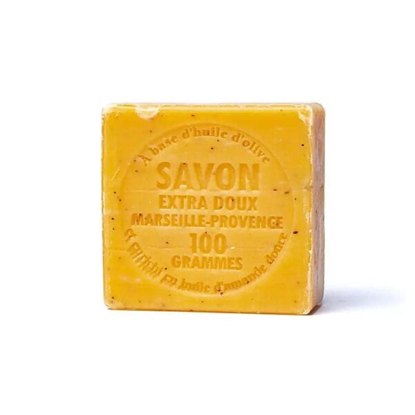 O tabletă de săpun galben cu inscripția „Savon Extra Doux Marseille-Provence 100 Grammes” pe suprafață. Săpunul pare să fie făcut cu ulei de măsline, așa cum sugerează textul din jurul inscripției centrale. Acest Exfoliant Săpun Natural Marseilles cu Caise are un aspect rustic și natural.