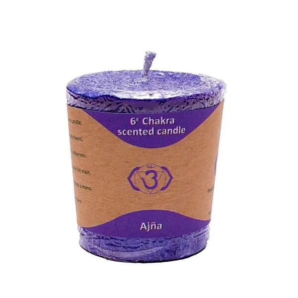 A purple Lumânare Votivă Parfumată Chakra a 6-a wrapped in a brown label with violet accents. Pe etichetă scrie „Lumânare parfumată Chakra a 6-a” și „Ajna” cu un simbol care seamănă cu un triunghi inversat cu un ochi în interior, reprezentând chakra al treilea ochi.